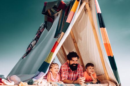 Funny summer holidays with family. Loving dad takes care about children. Little cute children feel...