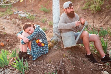 Eco farm. Summer farming. Image of two happy farmers with instruments. Farmars couple enjoy spring nature and take care about her plants.の写真素材