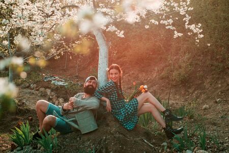 A farmer and his wife standing in their field. Smile Couple on farmland. Family of rural workers. Couple Gardener. Couple Farmers.の写真素材