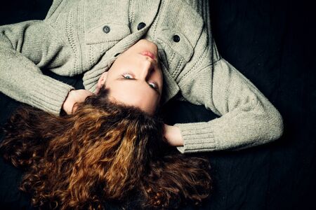 Portrait of confident man with long hair. Young handsome hipster guy looking brutal. Confident concept. Serious stylish man. Fashionable man looking at camera. Copy space. Isolated dark background.の写真素材