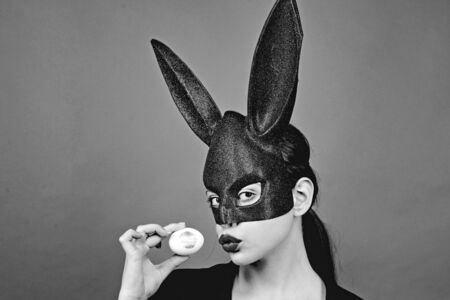 Easter woman. Woman rabbit, easter bunny girl. Red lip imprint on easter egg on red background....