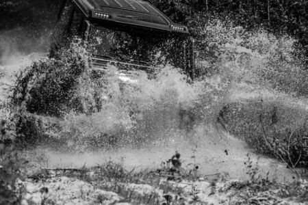 Off-road vehicle goes on mountain way. Offroad vehicle coming out of a mud hole hazard. Expedition...