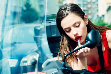 Beautiful brunette young woman wearing dress and walking on the street. Beauty and fashion. Portrait of serious woman. Young attractive cheerful woman walking in city. Active lifestyle. Paint lips.の写真素材