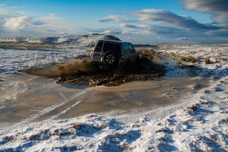 Off road car on mountain road. Travel concept with big 4x4 car. Extreme. A car sprays mud....