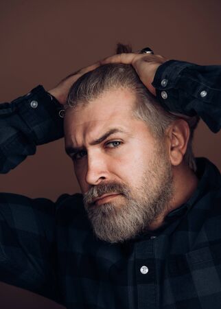 Sexy gorgeous stylish man. Close-up face of young bearded man on dark background - professional studio light.の写真素材