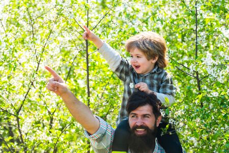 Father and son working together on farm. Happy family: father and children son on spring blossom...
