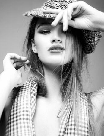 Making her beauty all the more striking. Pretty woman wearing fashion cap on long hair with beauty look. Beauty and fashion look of vogue model. She is such a beautyの写真素材