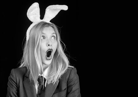 Bunny woman. Happy easter. Portrait of a happy woman in bunny ears winking. Easter bunny woman. Sexy woman with mask Easter bunny on a black background and looks very sensually.の写真素材