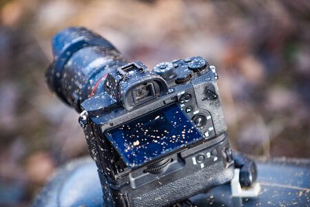 A dirty photo camera lens isolated on nature. Macro. Dustproof moisture protection. Close up dust...