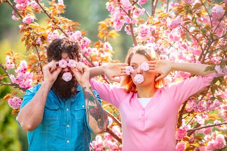 Easter couple, Romantic couple having a date in spring blooming park on a spring day with beautiful cherry blossoms in the background.の写真素材