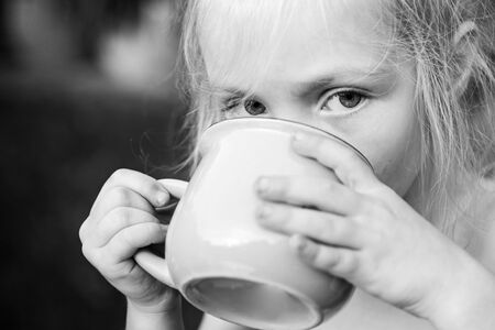 Break for drink. Girl drinking something. Water. Happy childhood. Child care.の写真素材