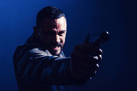 Killer or murderer concept. Head hunting. Man handsome mafia killer going to shot someone. Finish...