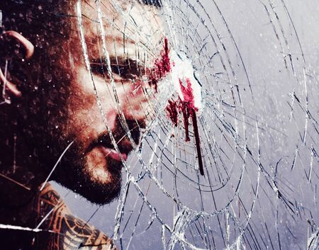 Strong horny man breaking window glass. Bloodstains at broken crushed glass. Blood stain at smashed...