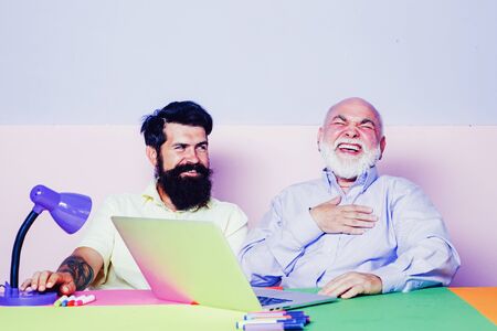 Happy businesswoman enjoying positive good news in Internet. Smiling and having fun in office. Businessmen using laptop and having fun together at work.の写真素材