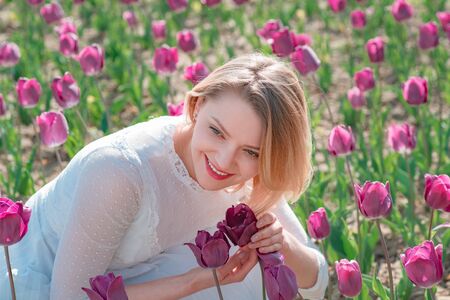 Lifestyle women feeling good relax and happy freedom on the nature tulip farm. Field of colorful bright red tulips.の写真素材