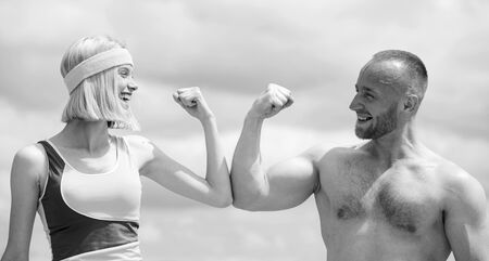 Beautiful smiling girl compares muscles with her strong handsome boyfriend and have fun. Shirtless...