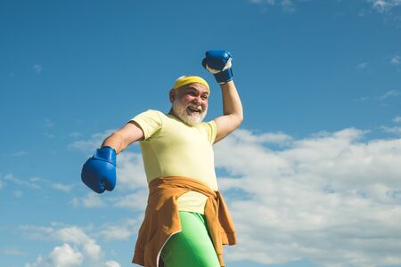 Happy Older man boxing. Senior men fighting poses. Boxer with boxing glove. Healthy fighter senior...