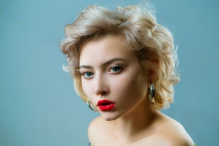Close up portrait of young beautiful woman with pinup style posing on gray Isolated background....