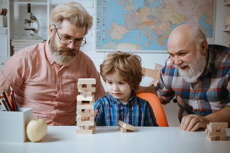 Grandfather, Father and son playing  game at home. Head shot portrait smiling grandfather, father and preschool son.の写真素材