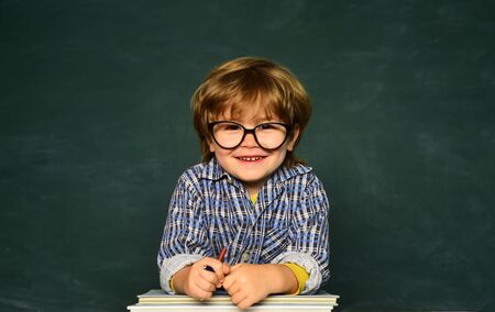 Back to school and happy time. September 1. Blackboard copy space. Happy smiling pupils drawing at the desk. Great study achievement.の写真素材