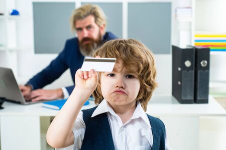Boss businessman holding credit card. Young business boy. Funny child in office holding Business...