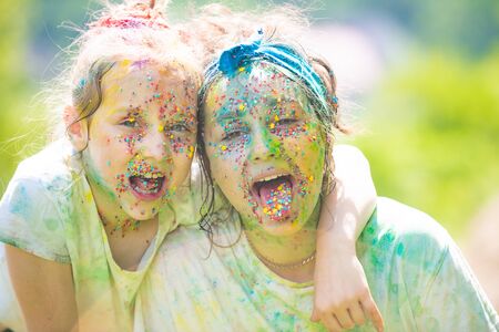 Funny kids face, colorful. Painted children face on colorful holi. festival of colors. Kids with...
