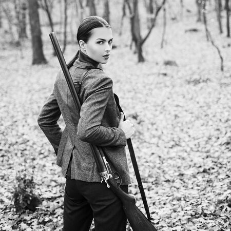 Hunter woman hunting. Hunting in autumn forest. Portrait of beauty woman Hunter. Hunting season.の写真素材