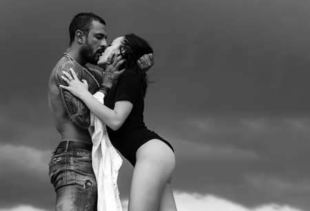 Muscular man and young female kissing. Beautiful young couple hugging. Love concept. Couple is...