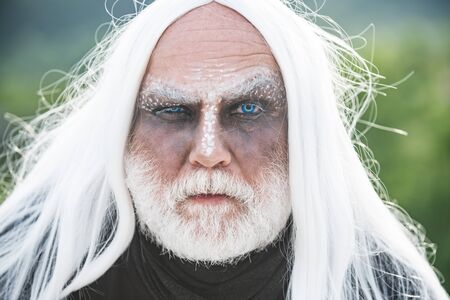 Devil man with angry face with Halloween make up. Devil vampire man. Happy Halloween - handsome Demon isolated on dark background.の写真素材