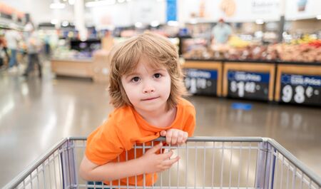 Healthy lifestyle for young family with kids. Cute toddler boy in a food store or a supermarket choosing fresh organic.の写真素材