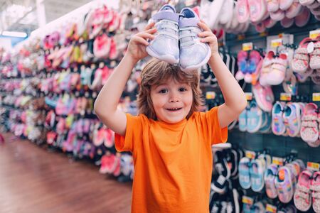 Kids shopping. Sale, consumerism and people concept. Kids shoes store in supermarket, choosing kids in shoes store. Shoes store for kids.の写真素材