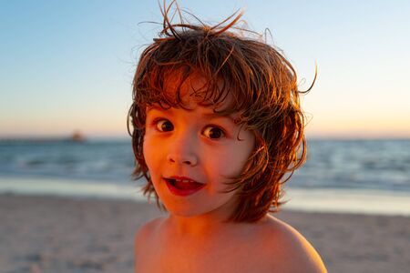 Portrait close up of cheerful little boy on summer sea.の写真素材