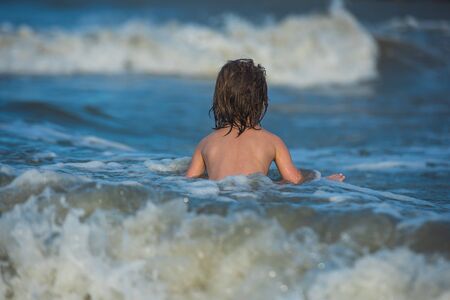 Child boy in nature with beautiful sea, sand and blue sky. Holidays at seaの写真素材