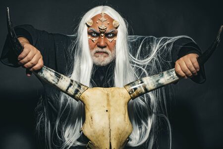 Vampire man with white eyes. Monster with sharp thorns and warts on face. Horror with scary Halloween man. Ancient alchemy. Man with a bull head. Devil horns.の写真素材