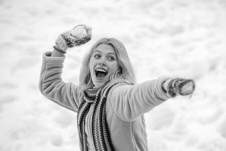 Winter girl. Cute playful young woman outdoor enjoying first snow. Portrait of a happy woman in the...