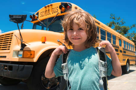 Child School concept. Portrait of Happy school child. Child from elementary school with bag on school bus backgroung.の写真素材