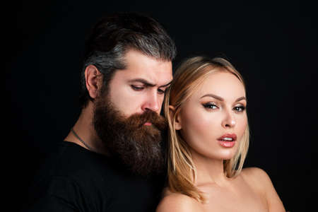 Portrait of stylish fashion couple on black background. Fashionable attractive couple posing on...