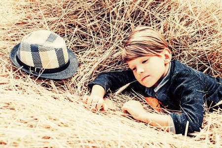 Cute boy on an autumn holiday in the village. The boy advertises childrens clothes for the autumn....