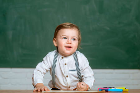 Preschooler is learning in class. Preschool kids at lesson. Chalkboard copy space. Little ready to study.の写真素材