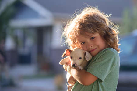 Child lovingly embraces his pet dog. Cute kids boy enjoying with her best friend dog. Positive emotions of children.の写真素材