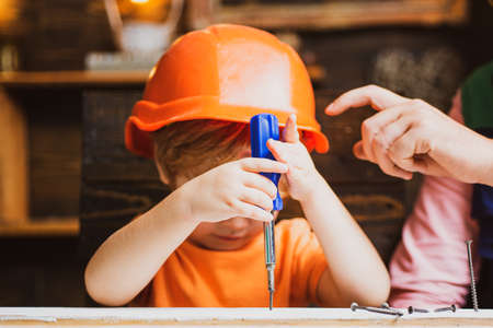 Child with a screw-driver. Kid boy using a screw driver. Early childhood education concept.の写真素材