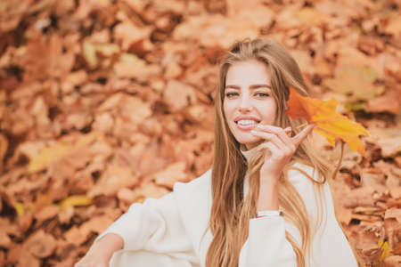 Autumn trend. Beautiful woman fashion model having fun in fall park outdoorsの写真素材