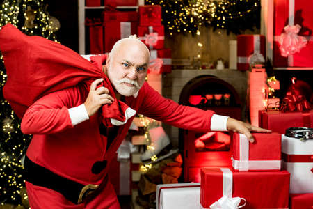 Thief stole new years presents. Criminal christmas. Criminal Santa Claus posing with a bag of...