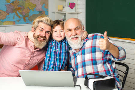 Grandfather, father and son computer games indoors. Pupil with Father, Grandfather enjoying time at...