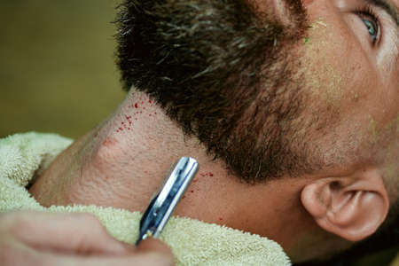 Barber in barbershop with bloody razor. Barbers blood.の写真素材