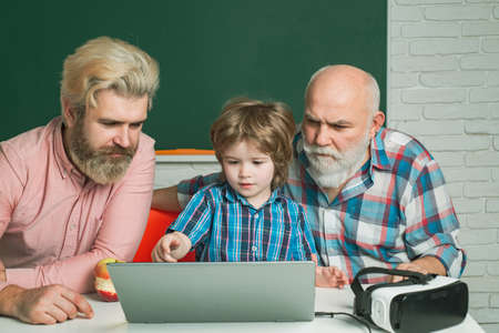 Man in different looking at laptop screen, social network. Old grandfather father and son using...