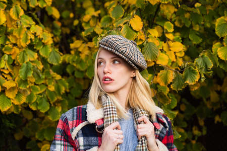 Beautiful femme wearing plaid scarf and cap in parisian style. Autumnal fashion concept. Beautiful...