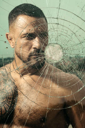 Bullet hole in glass. Destruction and crush test concept. Man style. Macho man glasscutter behind...