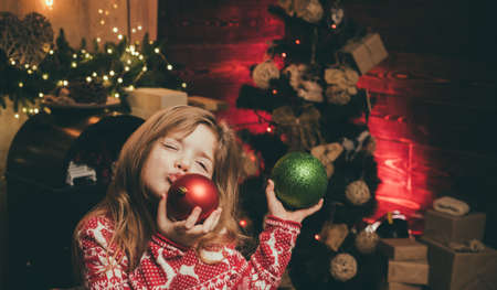 Sweet little girl with Christmas bauble. Cute little kids celebrating Christmas.の写真素材