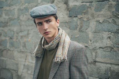 Fashionable man standing near a wall. Hipster fashion style guy.の写真素材